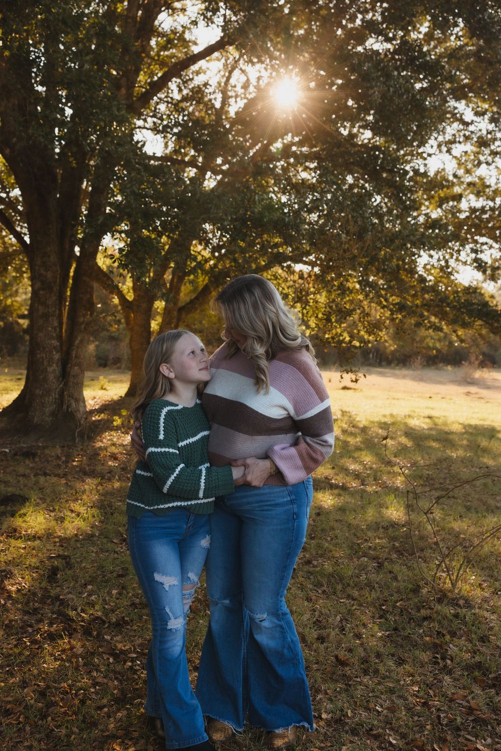A heartwarming moment captured at sunset beneath autumn trees in a golden field.