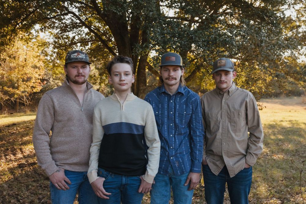 Family members pose together outdoors during golden hour in casual western attire for a group photo session.