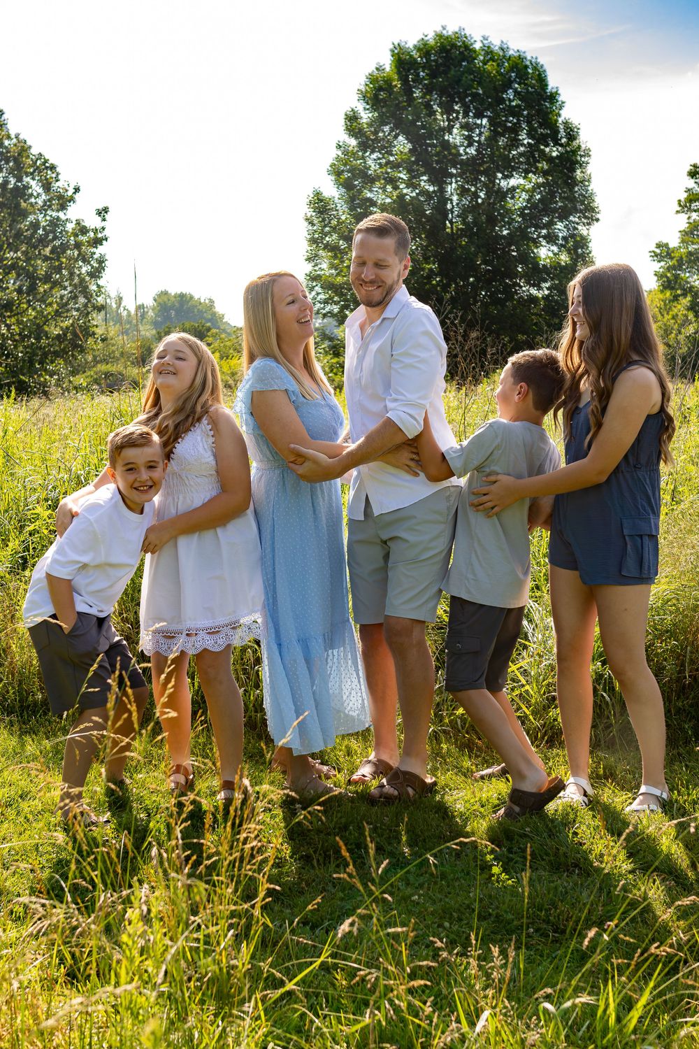 Group photo of people lined up in casual summer attire against natural backdrop.
