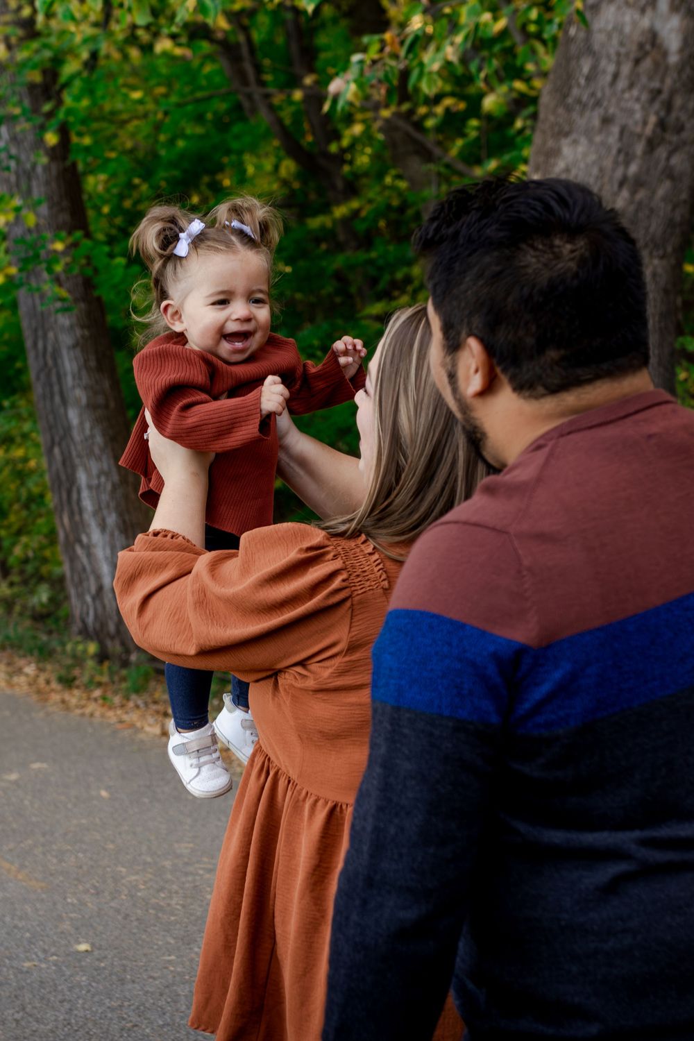 A heartwarming family moment captured in a wooded outdoor setting.