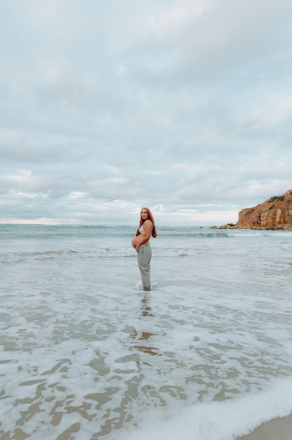 Dancing figure splashing through shallow ocean water against cloudy sky.
Altona Family Photographer Melbourne