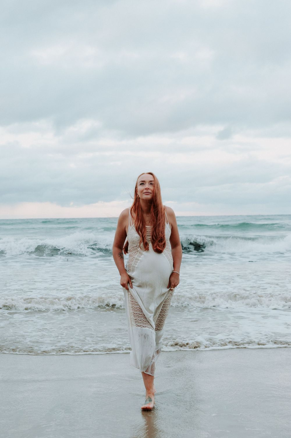Person in white dress frolicking joyfully in ocean surf.
Altona Family Photographer Melbourne