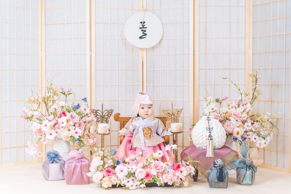Pink and white floral decorations with traditional Korean elements and gift boxes.
