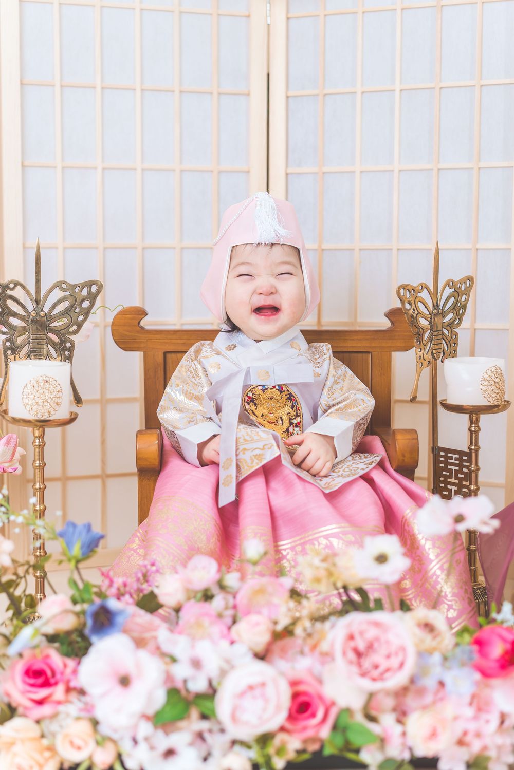 Festive celebration setup with pink floral decorations and traditional Korean elements.