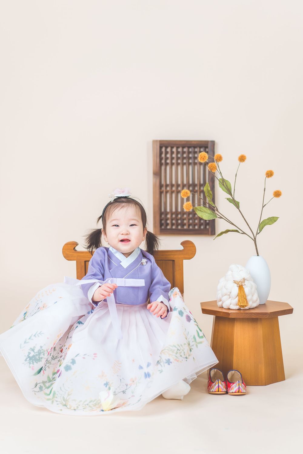 Traditional Korean celebration setup with wooden furniture and floral arrangements.