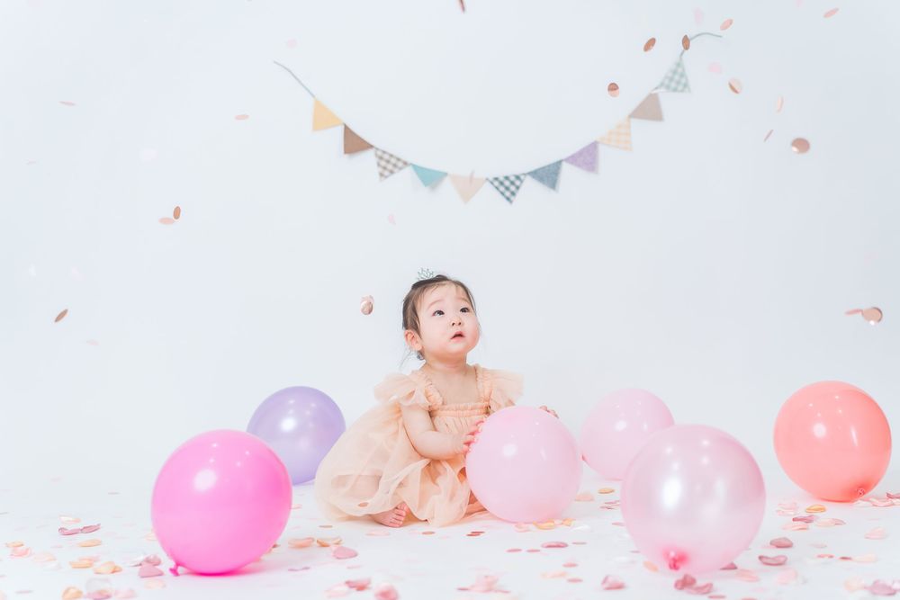 Birthday celebration setup with pink and purple balloons and party bunting.