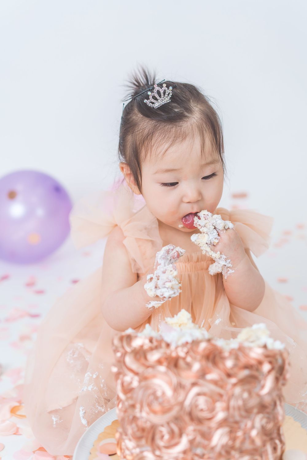 Elegant cake smash photo with rose gold cake and peach tulle dress.