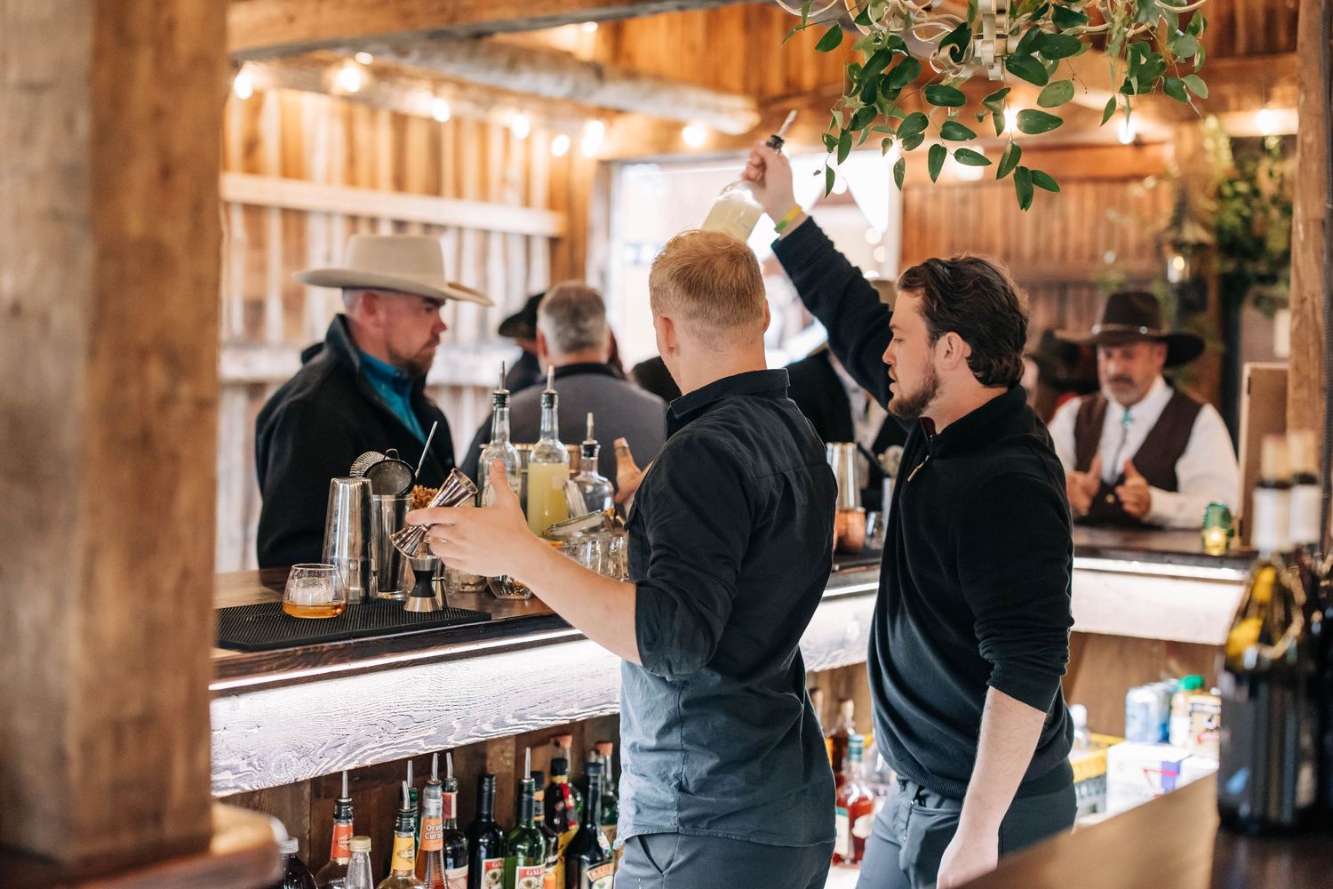A row of wooden barrels lines the white and red walls of a rustic barn or winery entrance area.