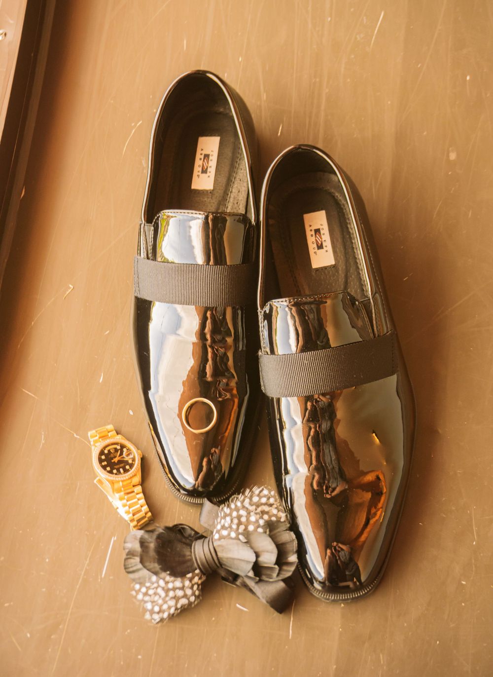 Colorado Springs Wedding Photographer. Photo of the groom's wedding ring, bow tie, and shoes displayed.