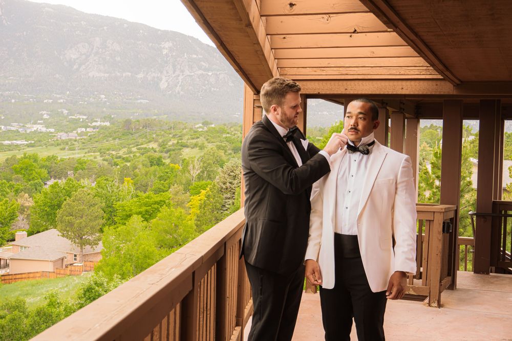 Colorado Springs Wedding Photographer. Photo of the groom and best man fixing their clothes for the big day.