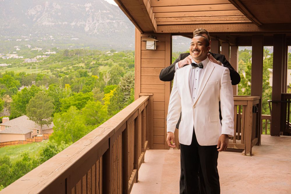Colorado Springs Wedding Photographer. Photo of the groom and best man fixing their clothes for the big day.
