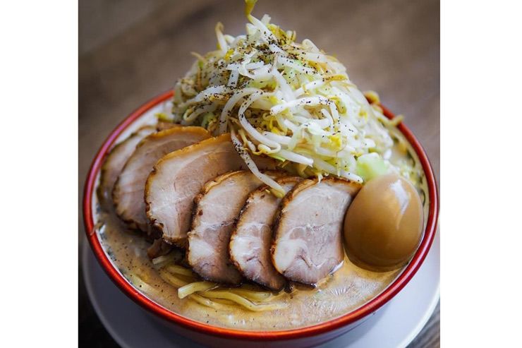 Sliced tender chashu pork served with marinated bamboo shoots and noodles in a rich ramen broth.