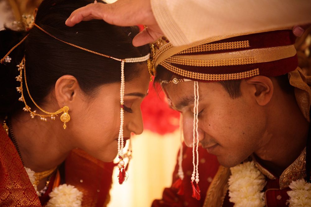 Sacred South Asian wedding moment with bride and groom touching foreheads in a Hindu ceremony, rich in tradition and emotion.
