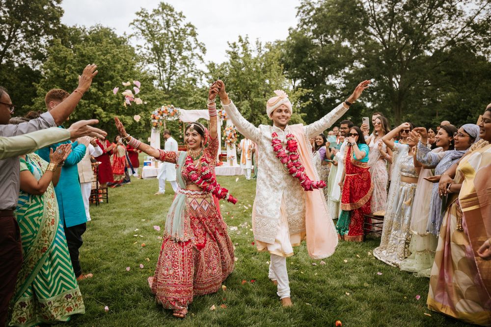 Joyful Indian wedding celebration at Rosewood Farms in Elkton, MD—bride and groom dance surrounded by cheering guests.