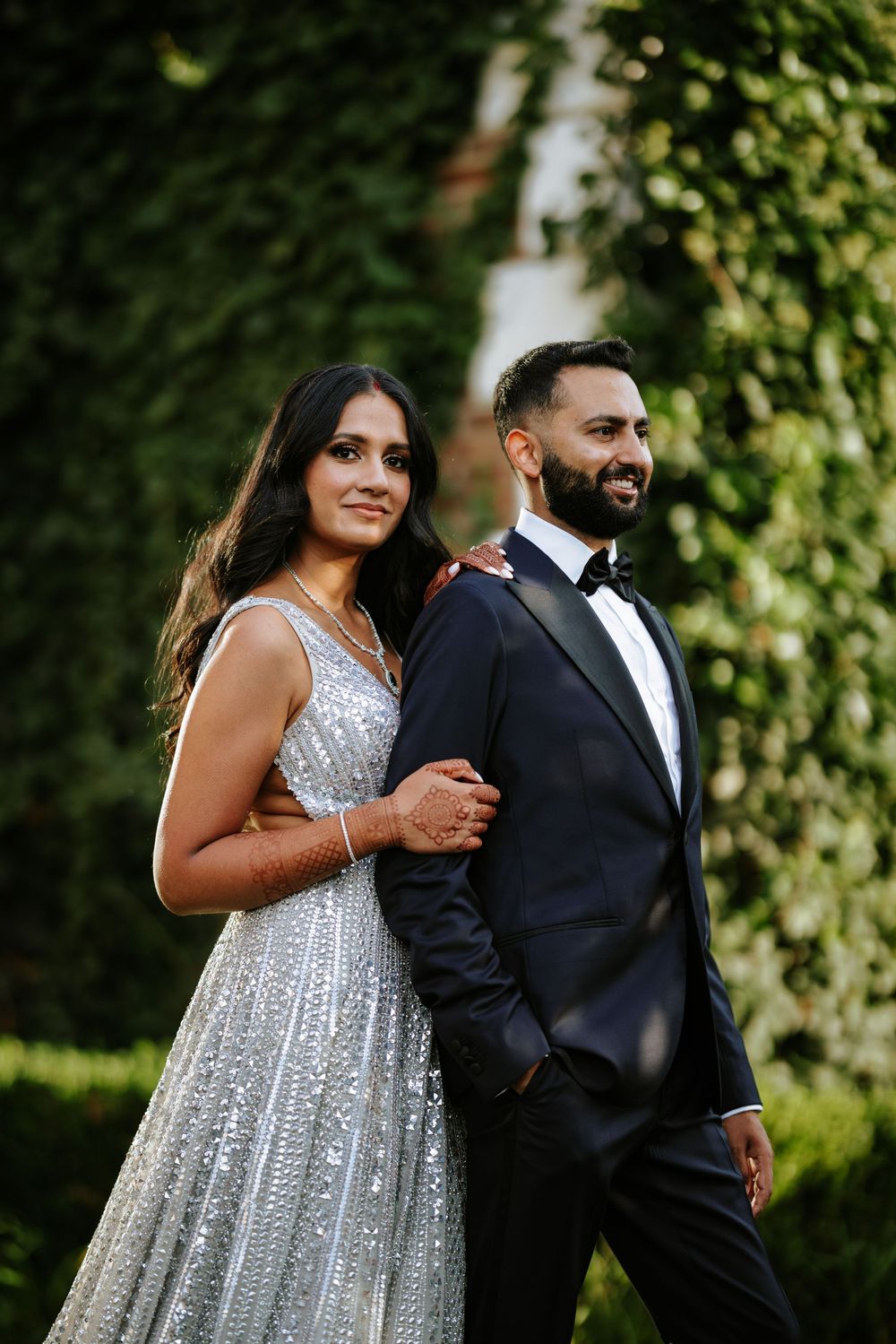 Elegant wedding portrait at The Rockleigh in New Jersey, with the couple posing stylishly against a lush green ivy backdrop.
