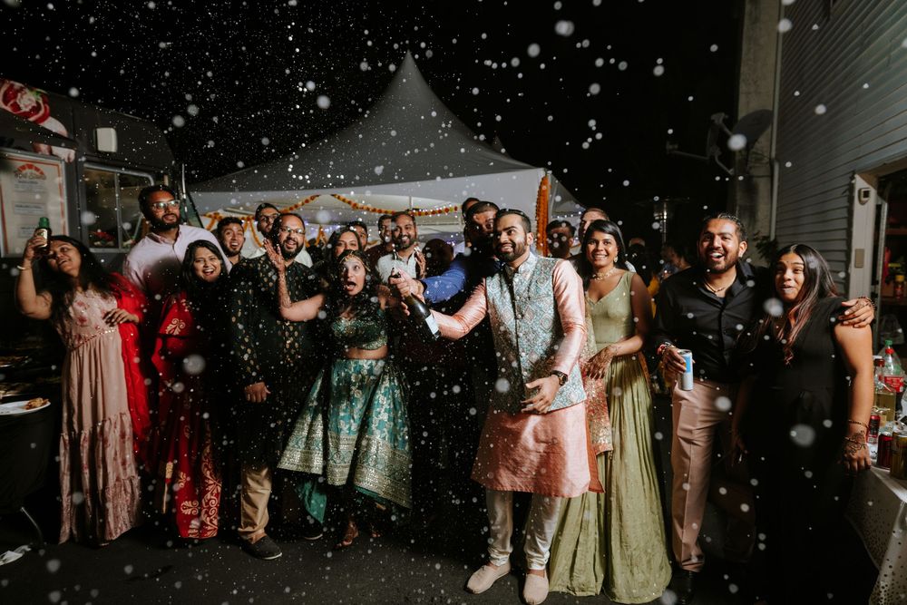 Joyful night celebration with guests dancing in the snow at Sheraton Parsippany, NJ—fun and candid South Asian wedding reception moment.