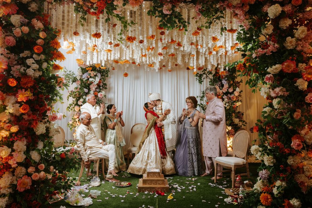 Wedding ceremony setup with elegant floral arrangements and white draping creating a romantic indoor garden atmosphere.