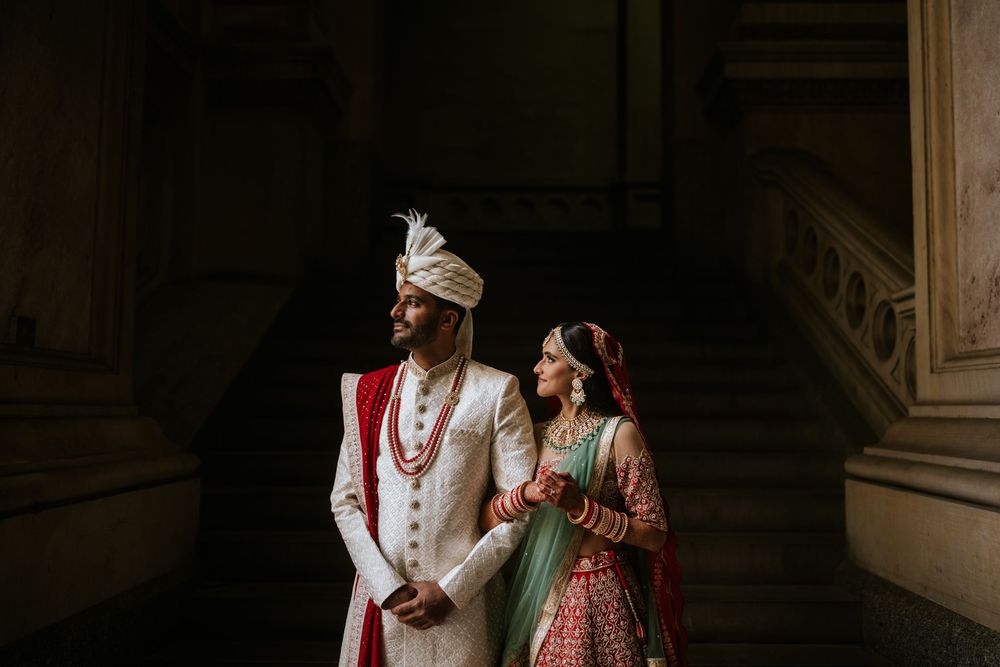 A couple in traditional Indian wedding attire shares an intimate moment during their ceremony.