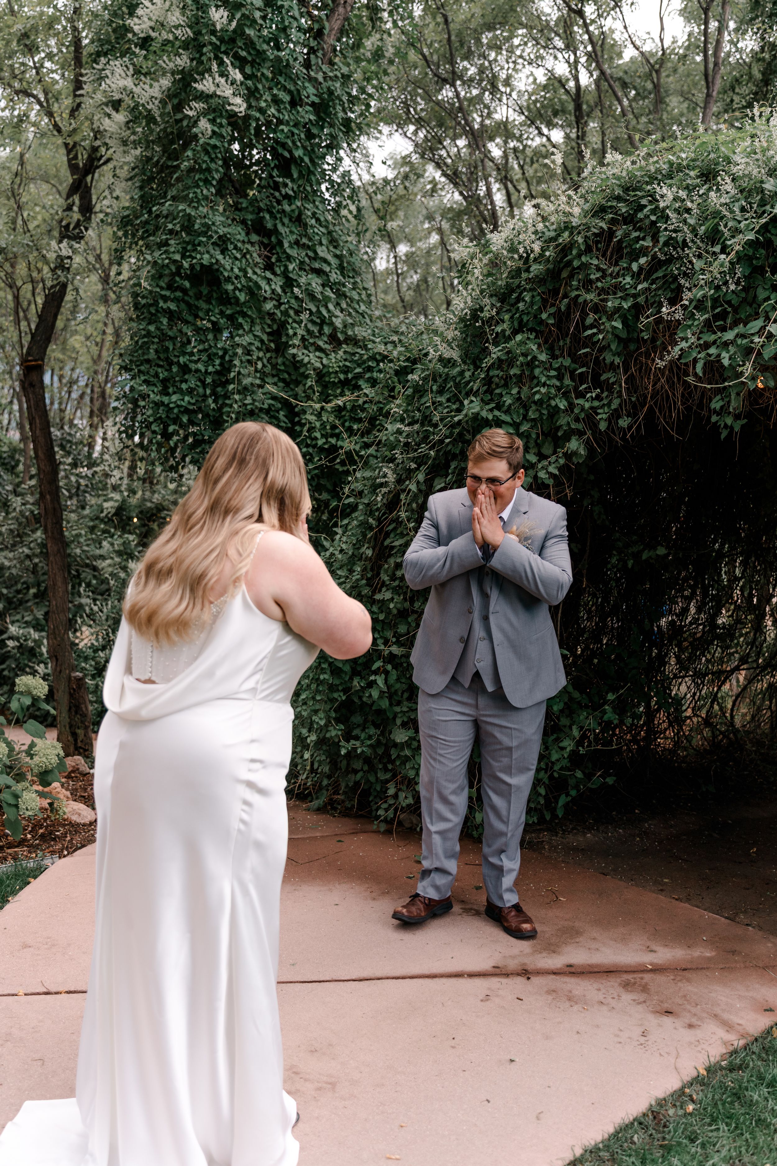 A first look sequence showing a couple in wedding attire sharing an emotional moment in a garden setting.