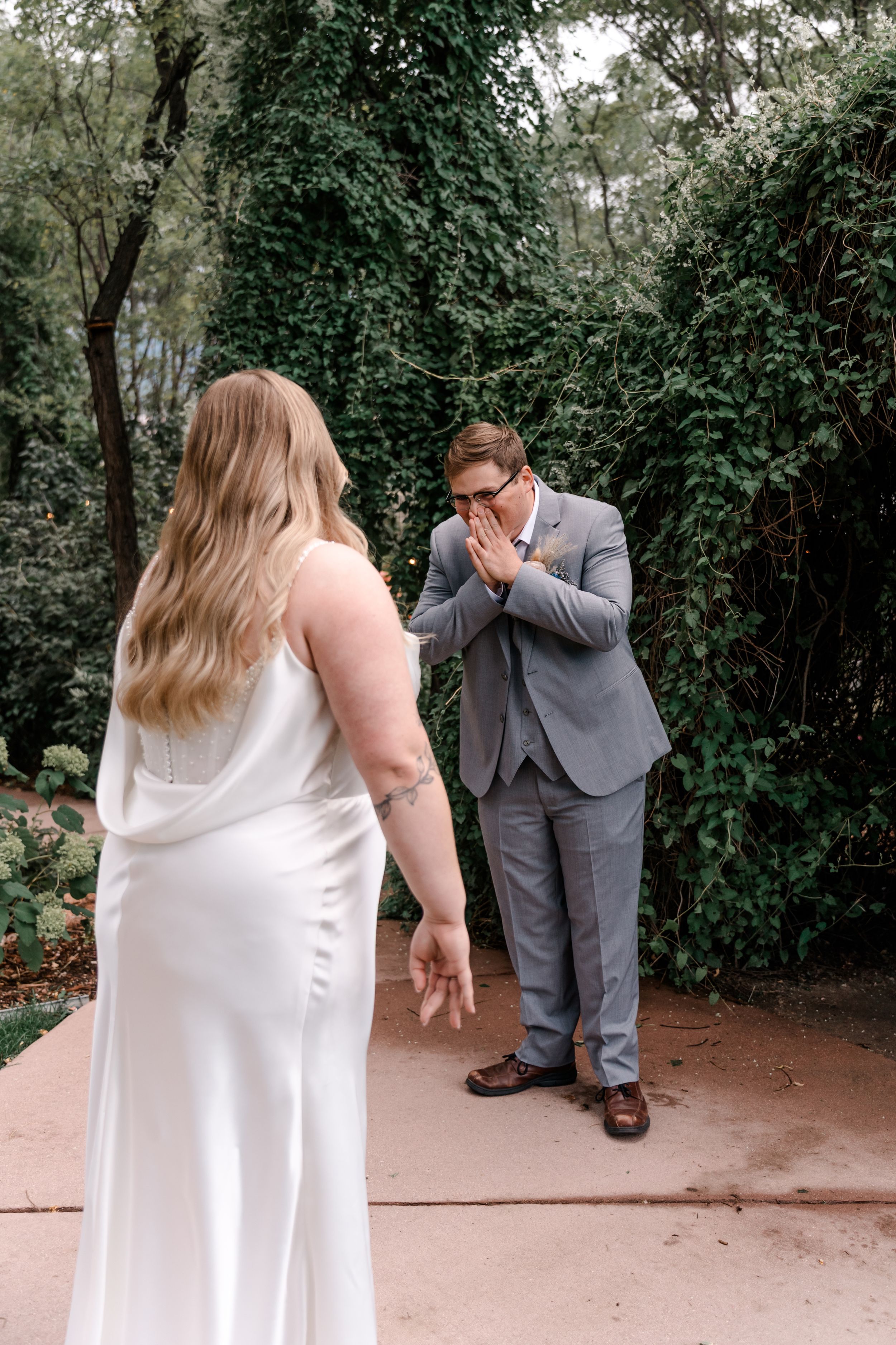 A couple shares an emotional first look moment in a garden setting, captured in a sequence of candid photos.