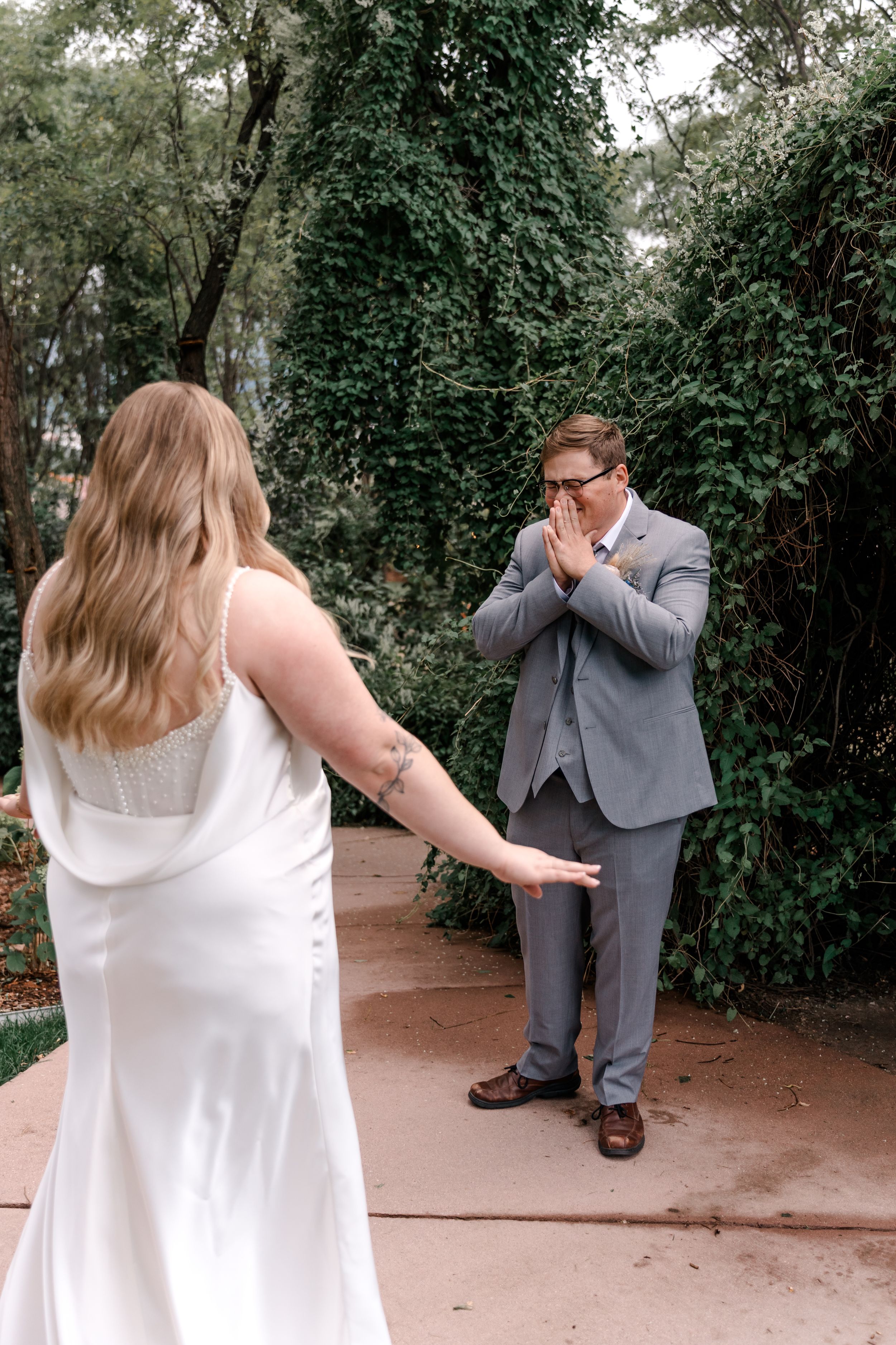 A series of candid wedding photos showing emotional reactions during a first look moment in a garden setting.