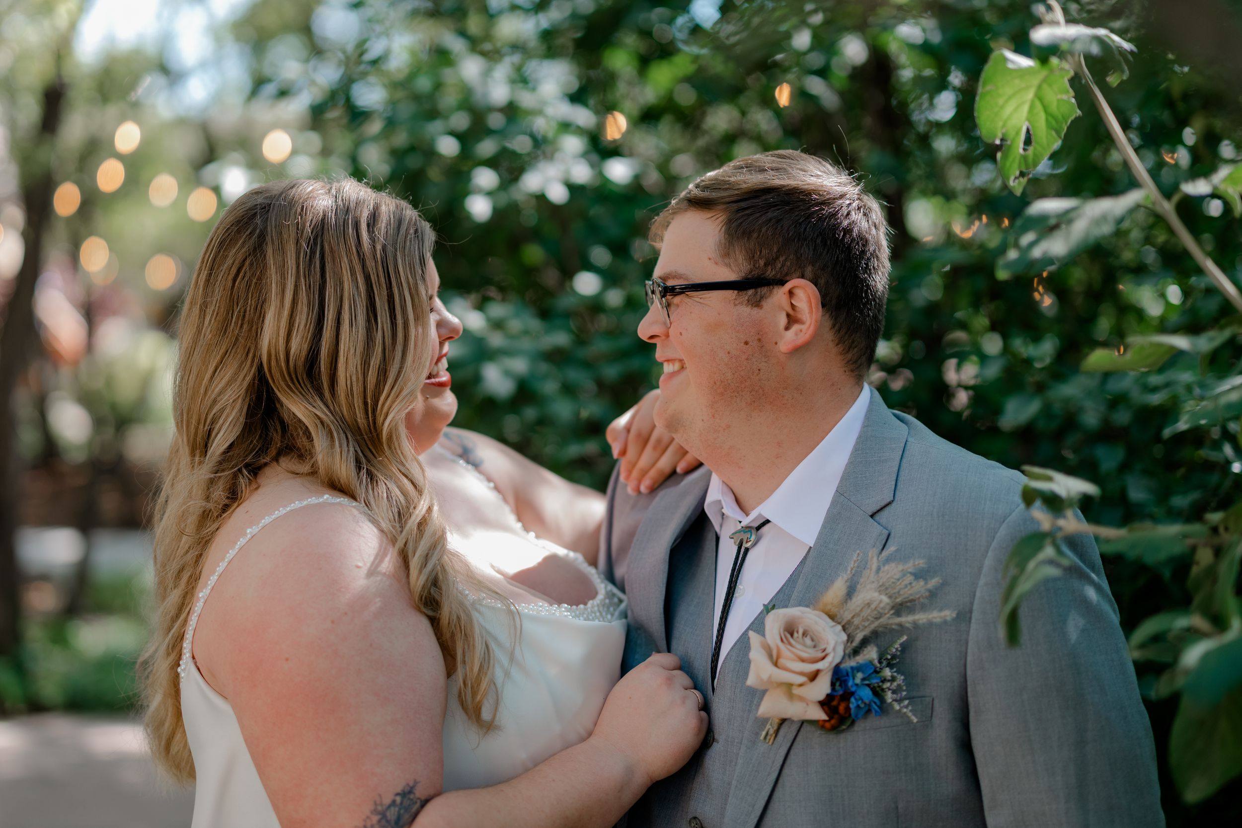 A romantic couple shares intimate moments in a garden setting during their wedding celebration.