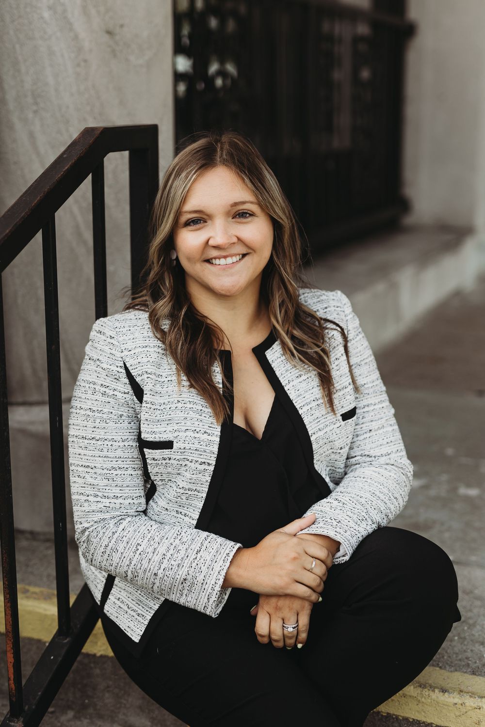 Professional headshot series showing a person in a black outfit and white tweed jacket posing against a dark background.