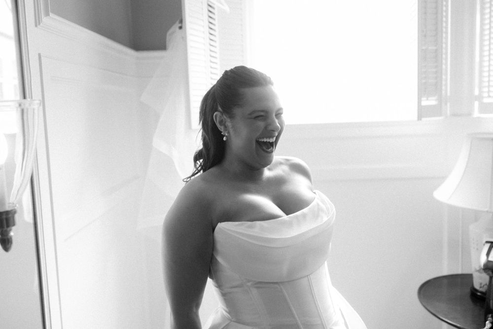 Black and white wedding preparation photos showing details of a bride's strapless dress.