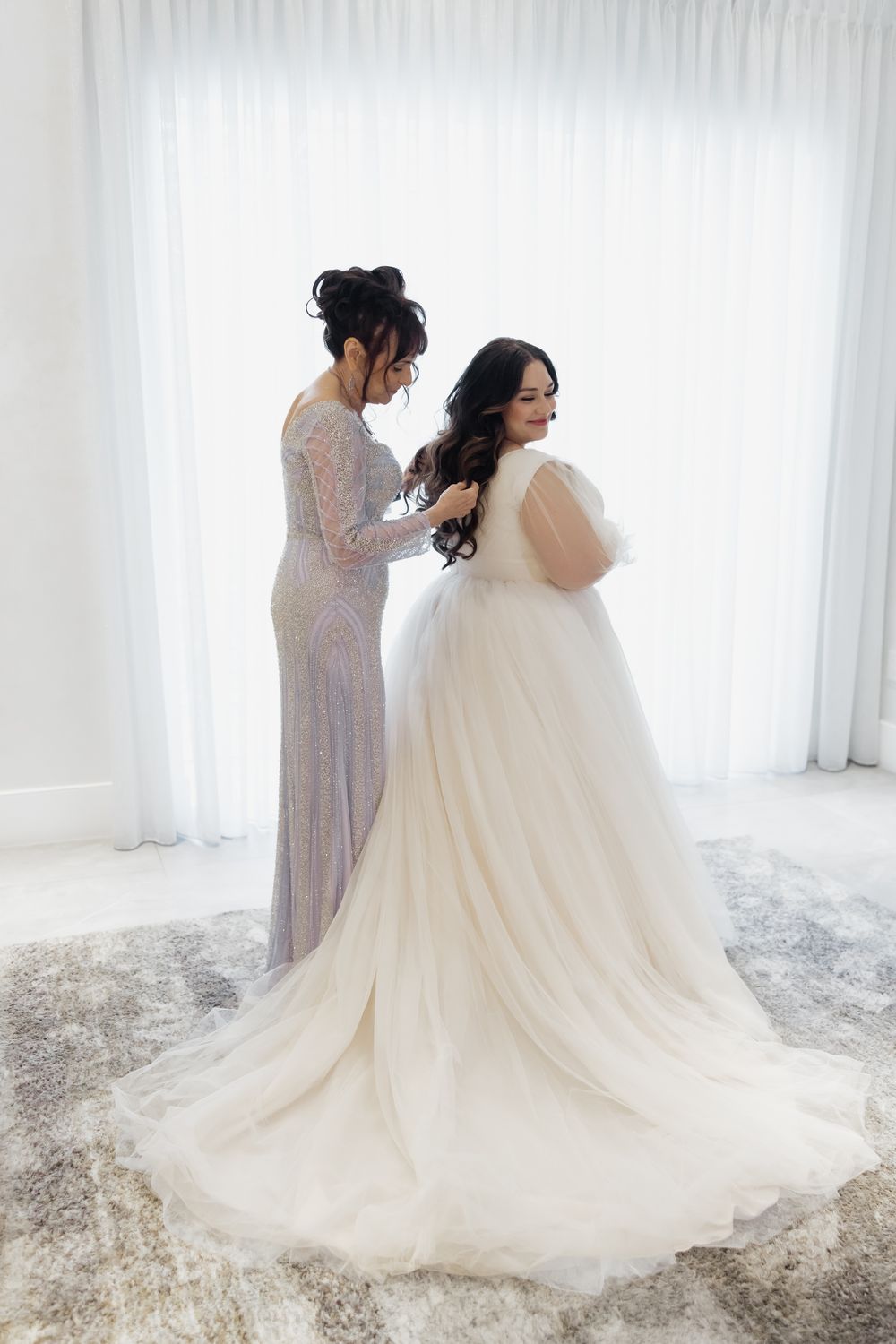 A flowing white wedding gown with a dramatic train photographed in a bright studio setting.