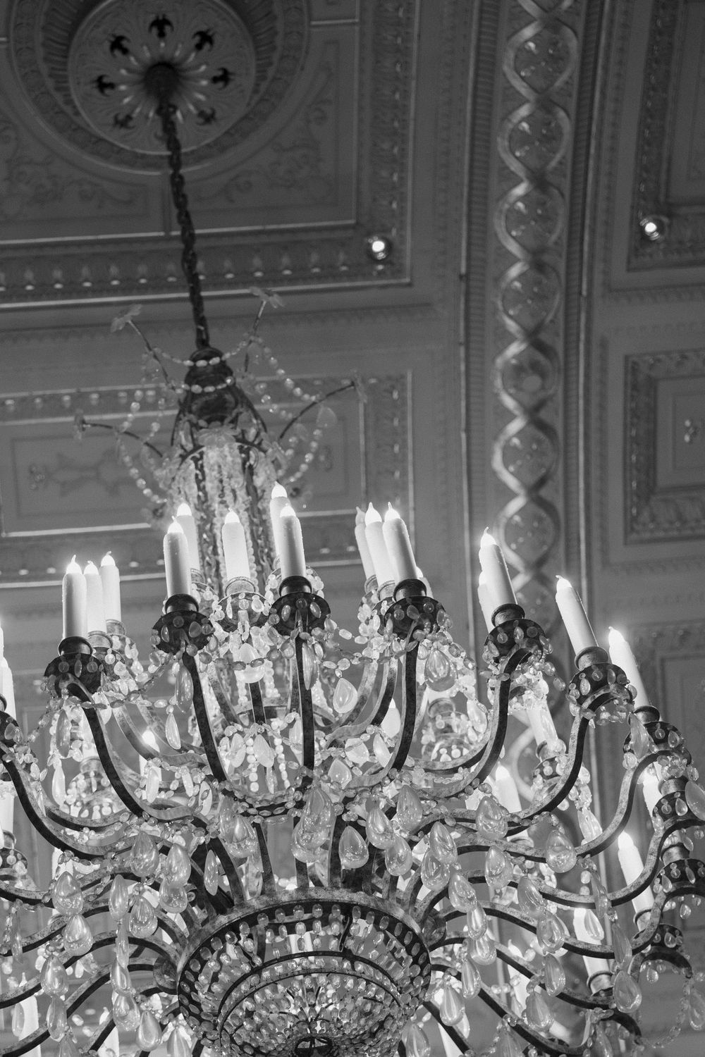 Crystal chandelier detail shot in an ornate ballroom ceiling.