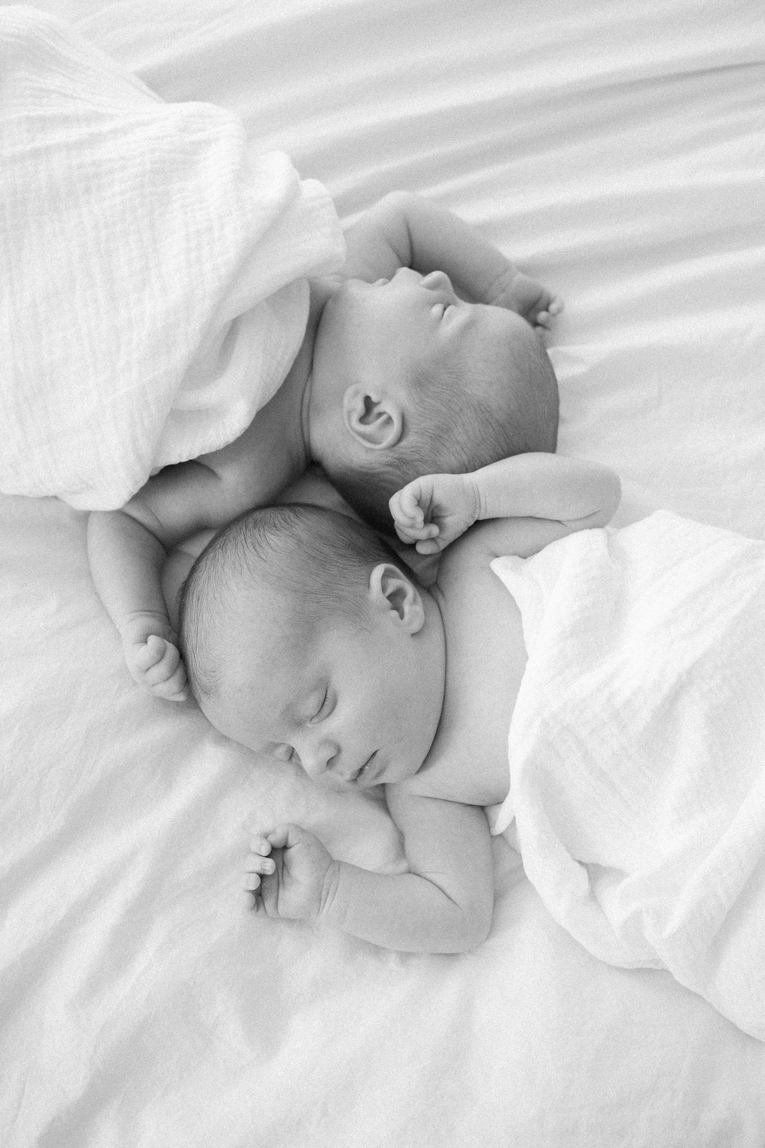 A sleeping newborn baby in white bedding shown from three different angles in a black and white photo series.
