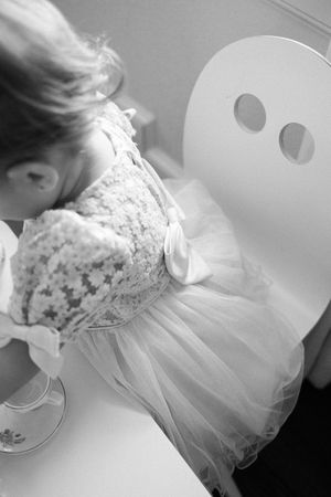 A black and white photo shows a lace and tulle ballet dress with a white mask resting nearby.
