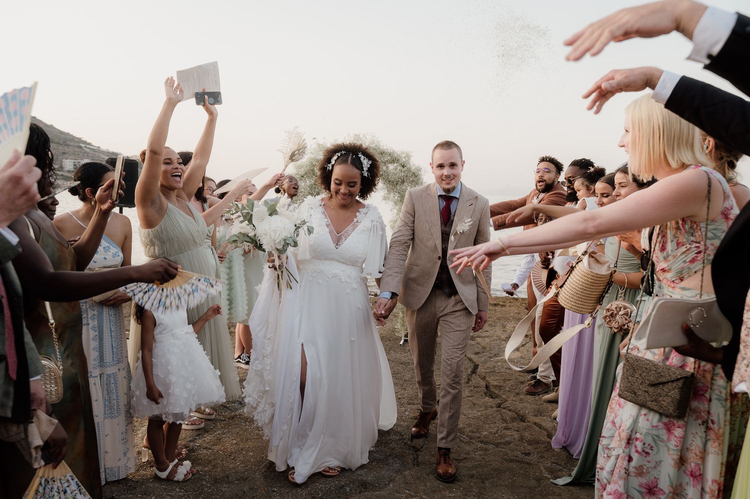 A candid photo of a couple's exit from their multiethnic boho wedding ceremony in Athens riviera Greece