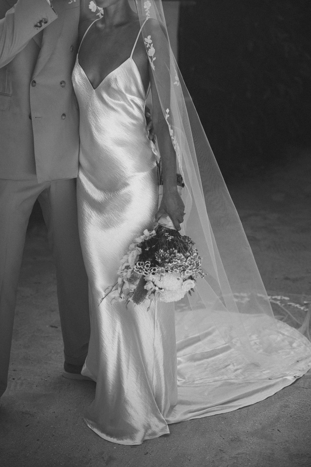 Black and white wedding portrait showing flowing dress and veil details.