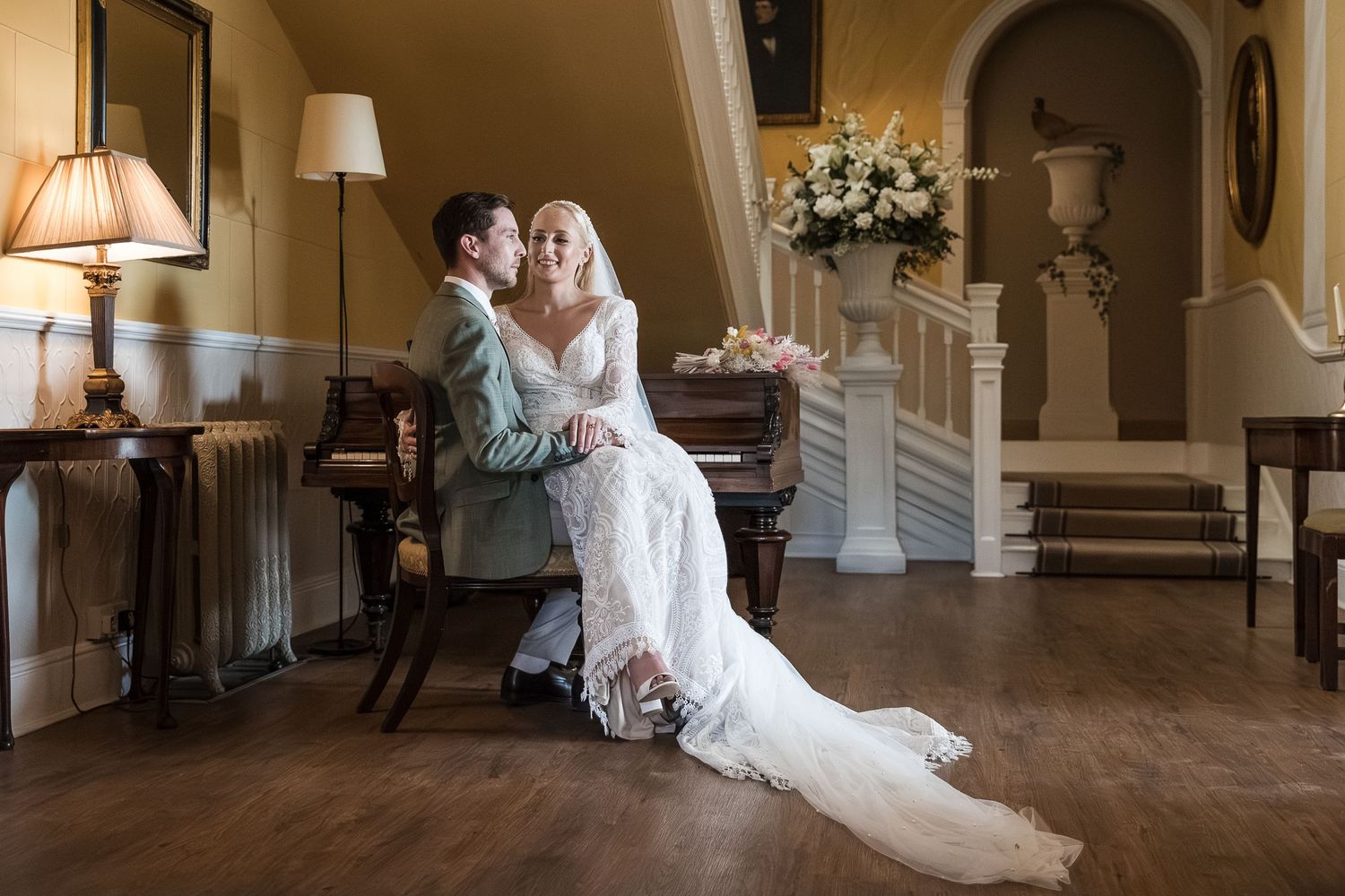 Couple sharing a romantic moment at the piano at Hodsock Priory