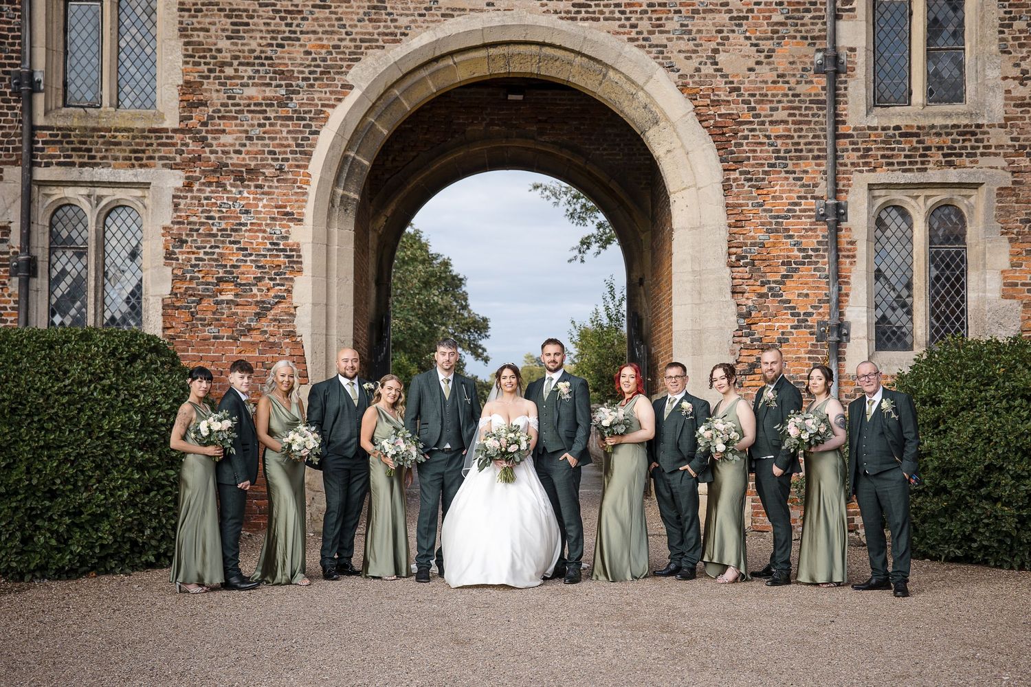 Wedding group photographed in the grounds of Hodsock Priory in front of the Gatehouse