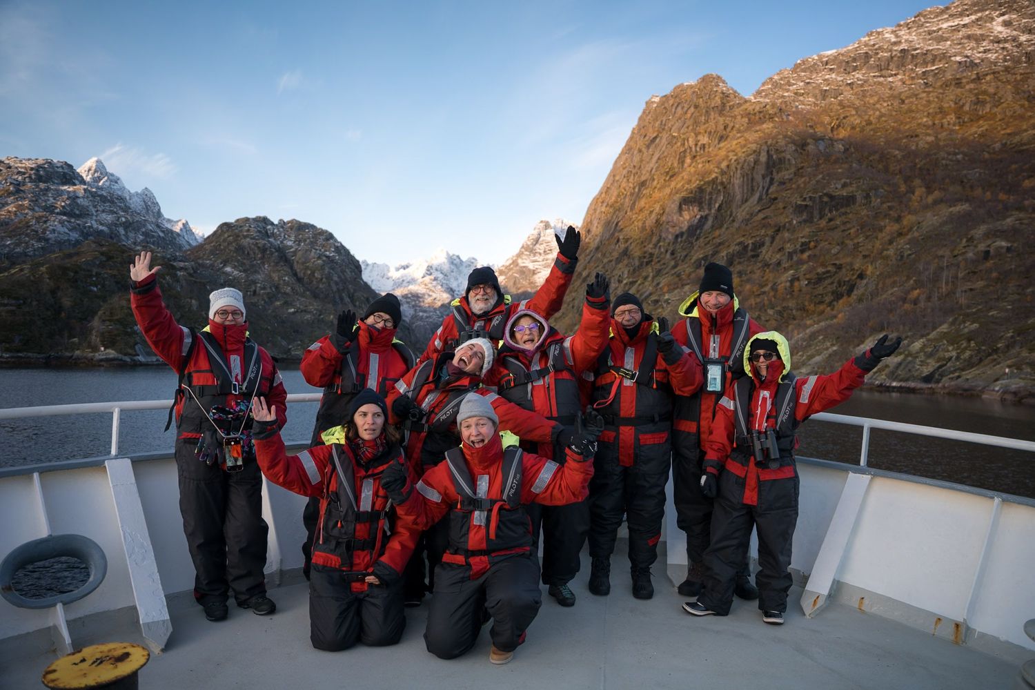 passagers de la croisière latitude blanche en tenue de zodiac devant trollfjord sur la passerelle du polarfront