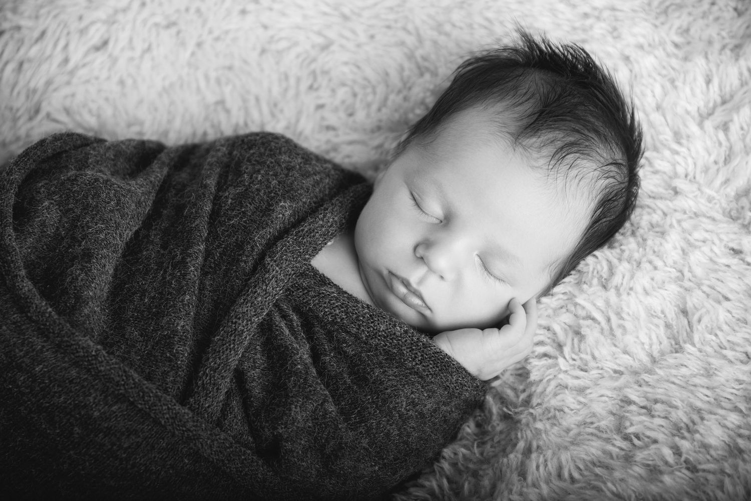 Professional newborn portrait in Gilston home studio with soft cream textures.