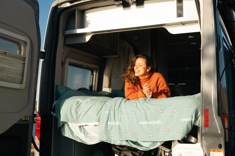 Multiple views of comfortable sleeping area inside a camper van.