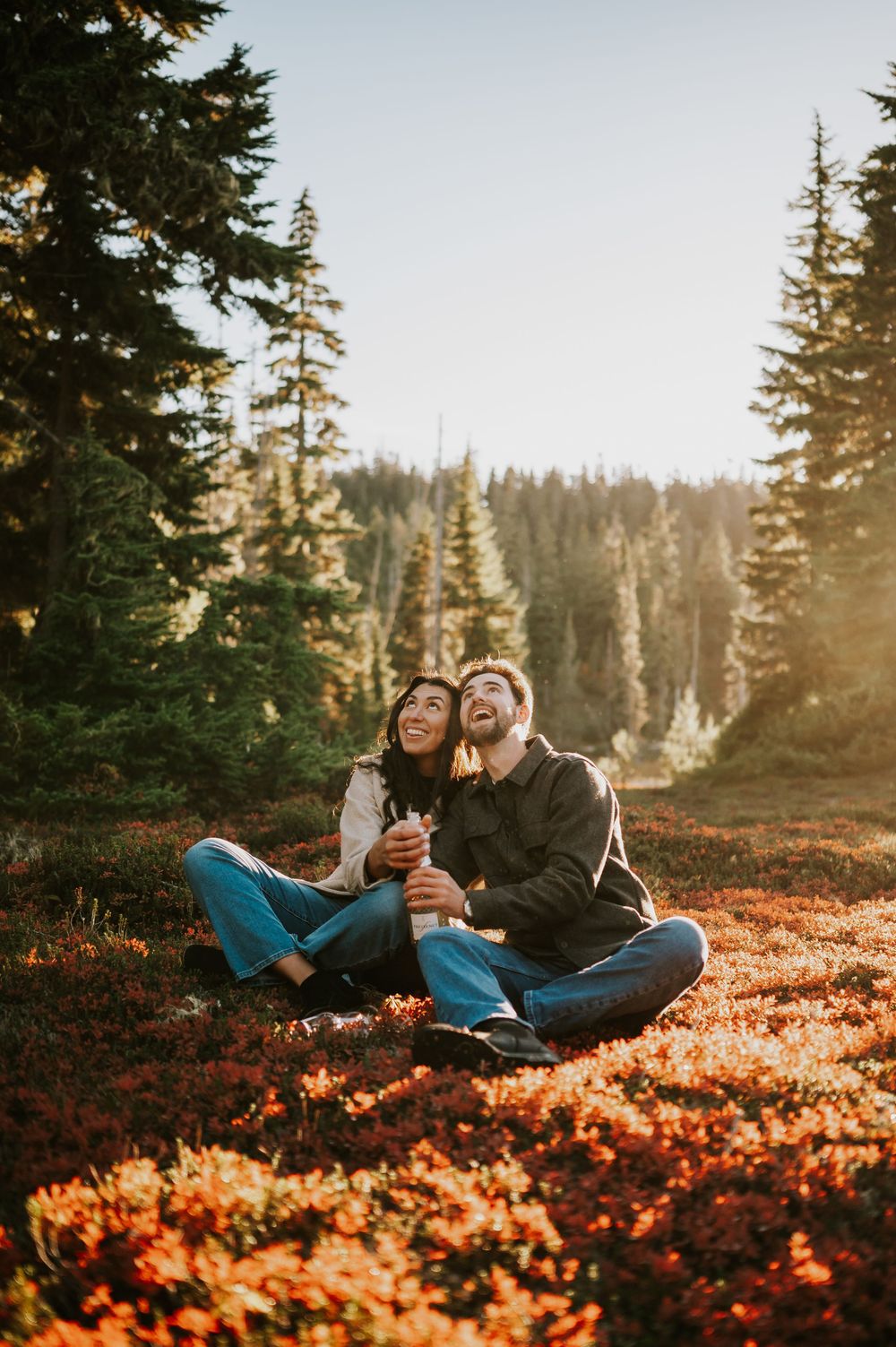 Engagement fall adventure photoshoot on Mt. Washington of couple popping champagne in blueberries in Paradise Meadows Vancouver Island