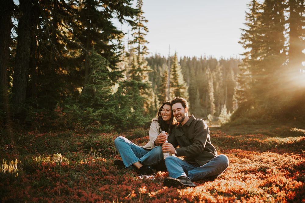 Engagement fall adventure photoshoot on Mt. Washington of couple popping champagne in Paradise Meadows Vancouver Island