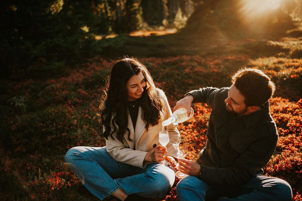 Engagement fall adventure photoshoot on Mt. Washington of couple pouring champagne in Paradise Meadows Vancouver Island