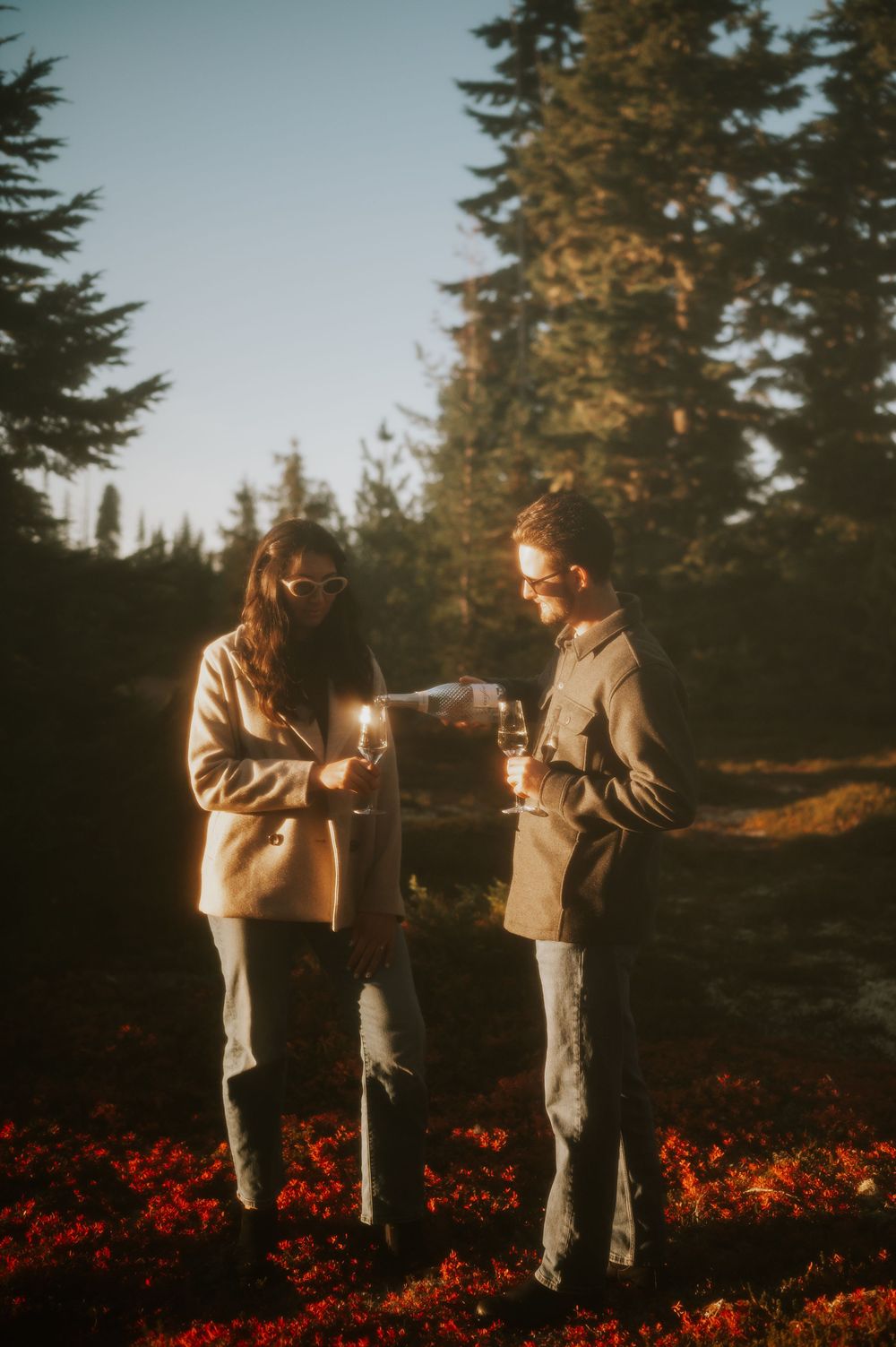 Film edit engagement fall adventure photoshoot on Mt. Washington of couple pouring champagne in Paradise Meadows Vancouver Island