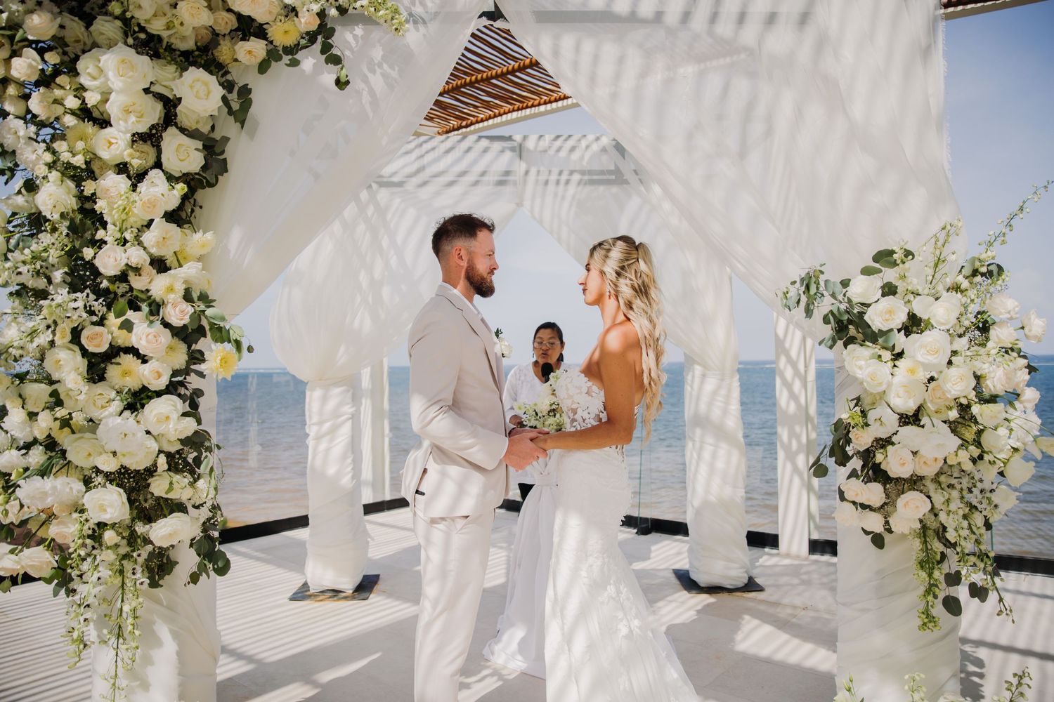 Seaside wedding ceremony with white floral arrangements Dreams Sapphire Riviera Maya Wedding Photography