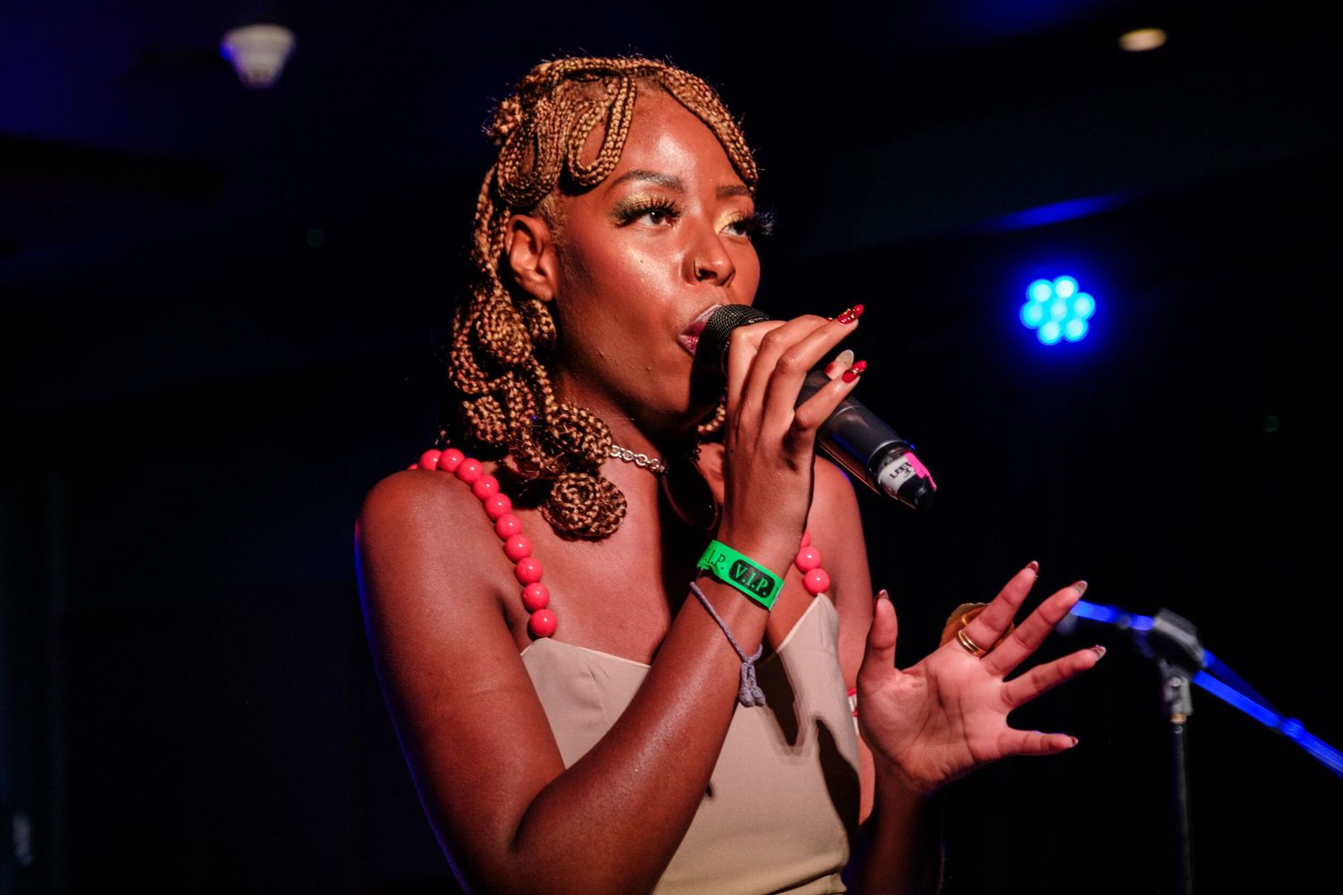 Live performance at a dimly lit music venue with blue stage lighting creating an atmospheric ambiance.