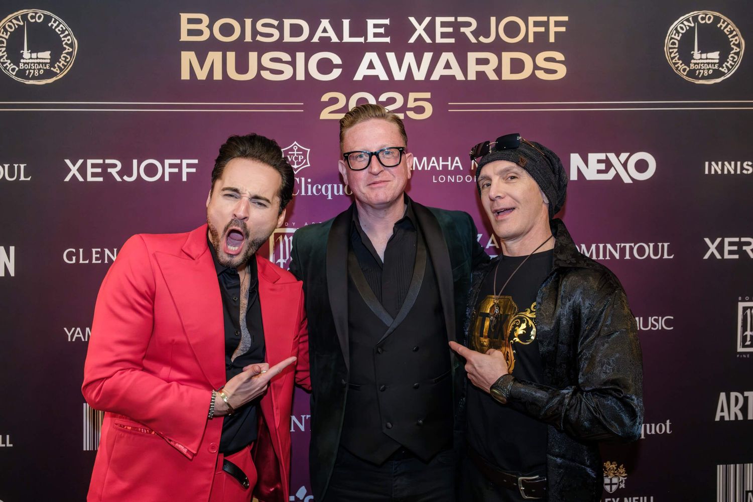 Three people pose together at the Boisdale Xerjoff Music Awards event against a branded step and repeat backdrop.