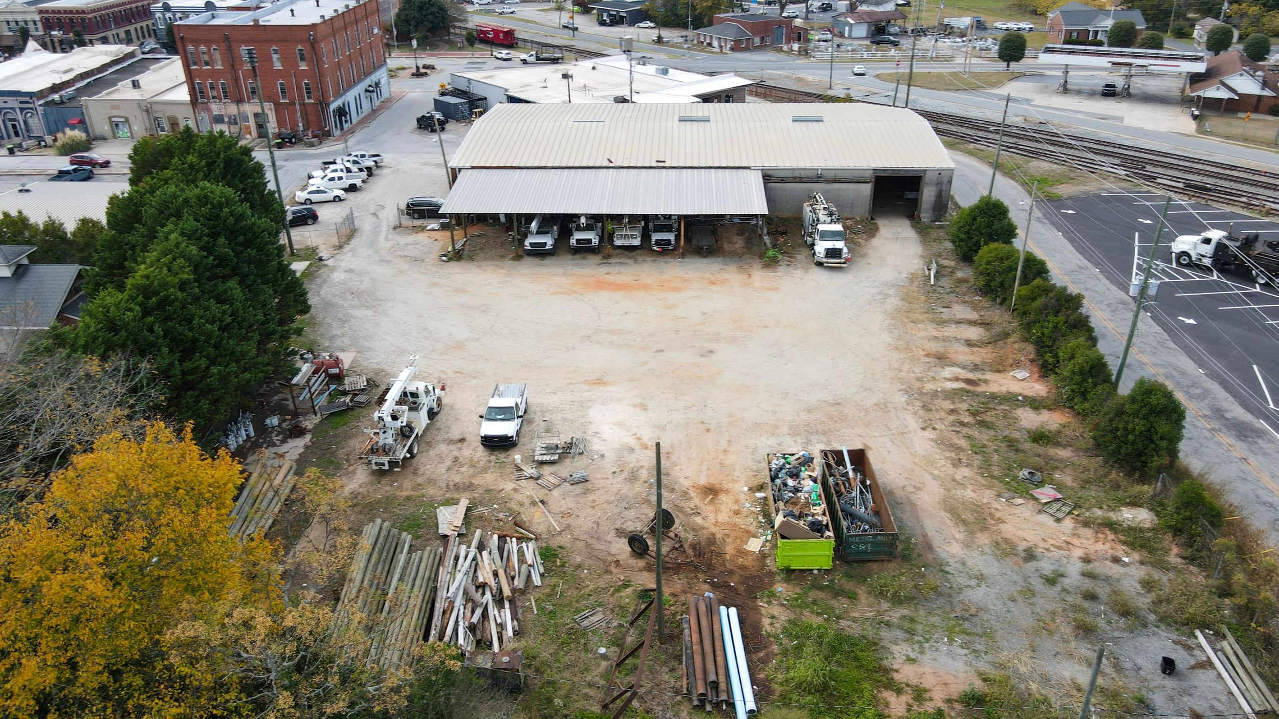 Aerial panoramic view of a construction site with industrial equipment and materials in an urban setting.