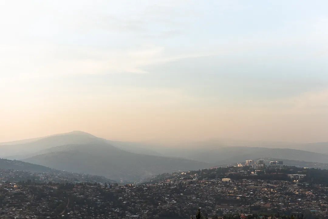 Soft sunrise over distant hills and rocky landscape, showing calm morning light and peaceful mountain scenery.