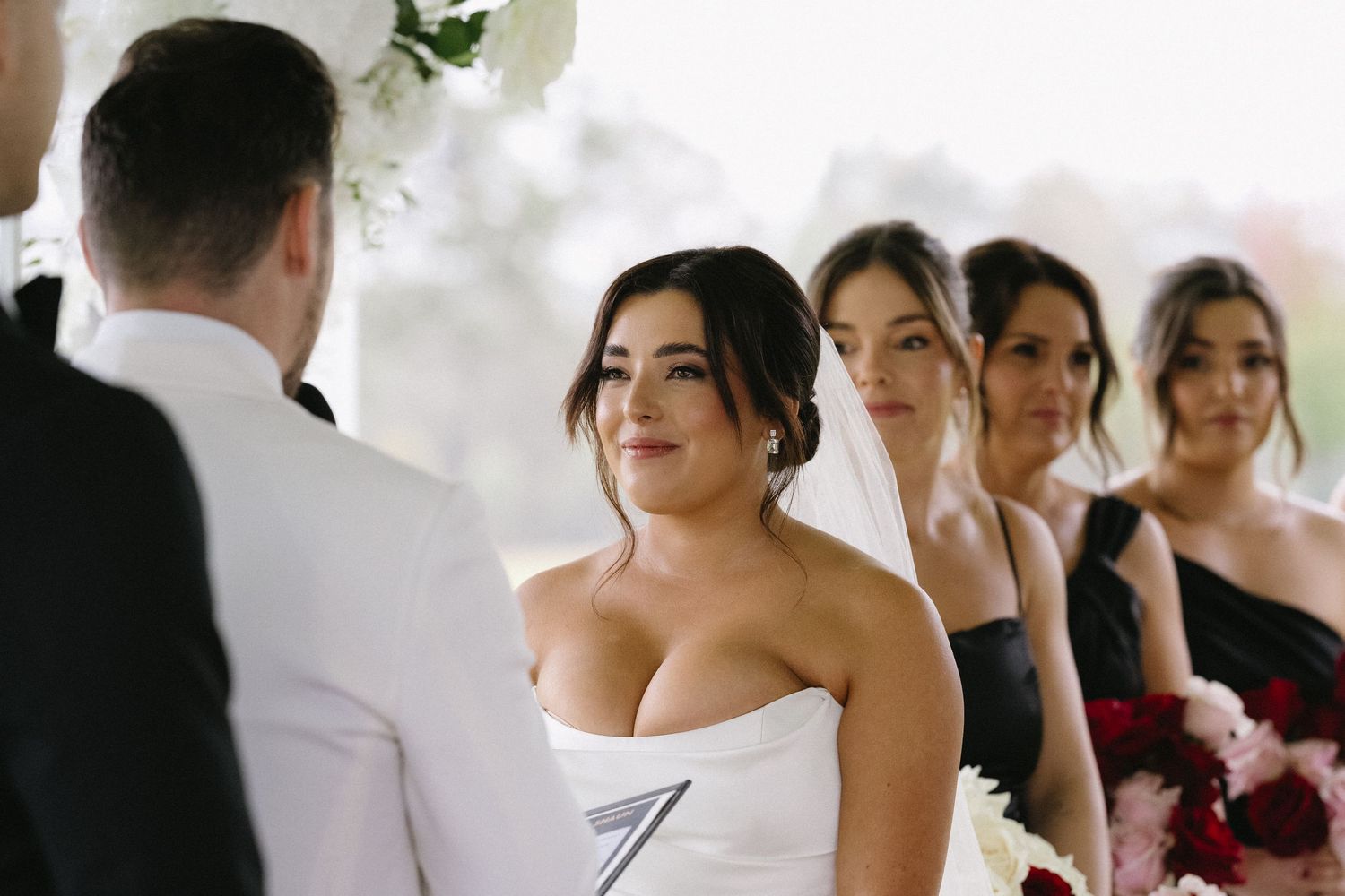 Wedding ceremony at an outdoor venue with bridesmaids in formal attire.