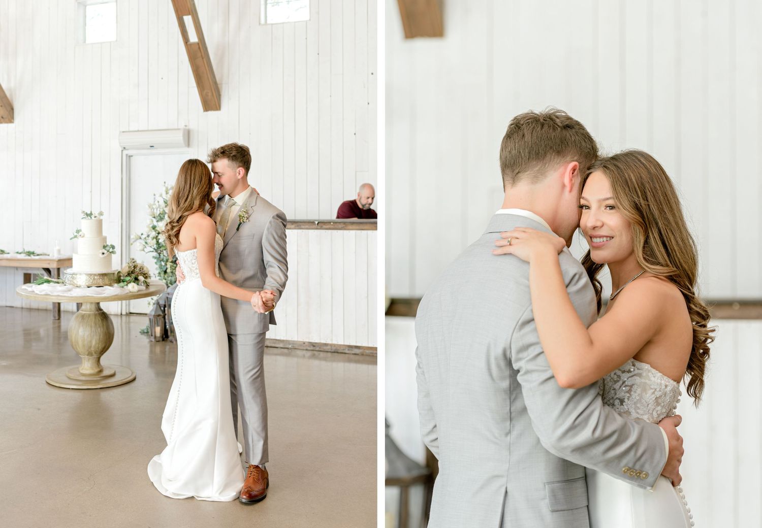 Romantic wedding couple shares intimate moment in white rustic indoor venue with exposed beams.